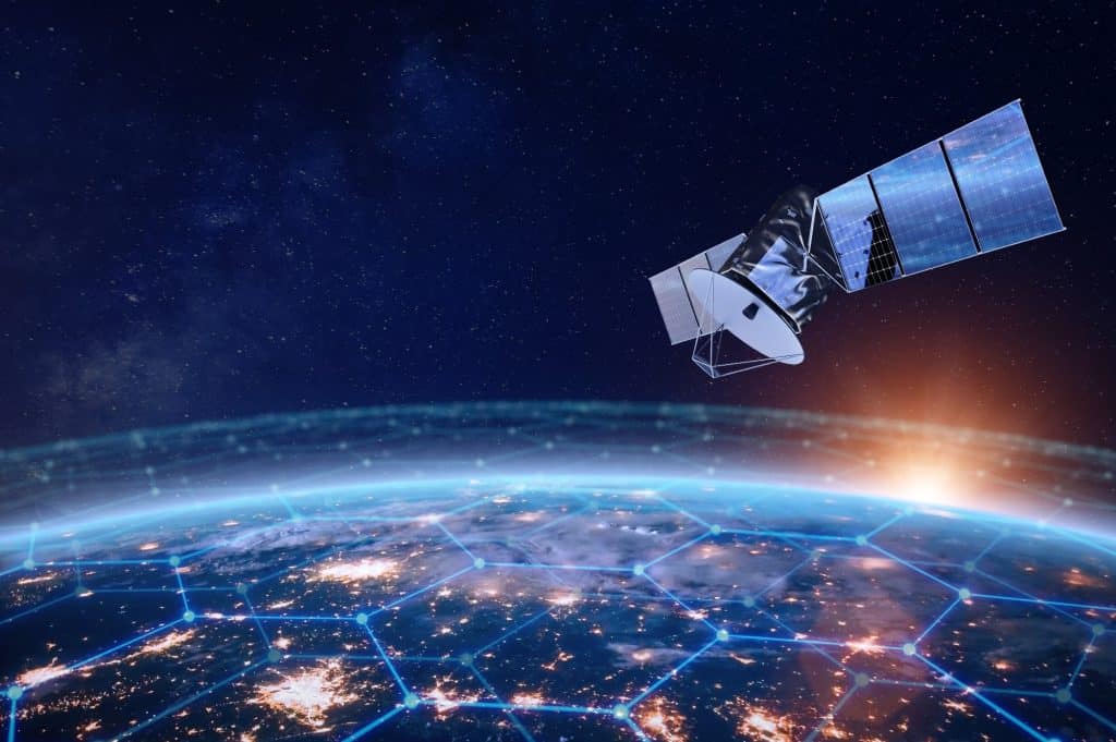 Imagem de um satélite de telecomunicações no espaço, passando pela órbita baixa da Terra