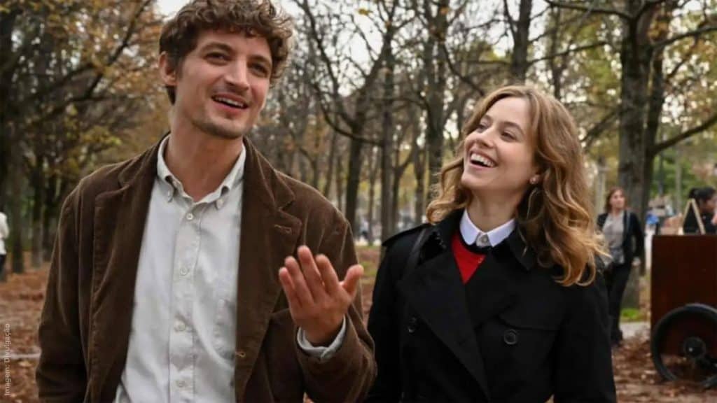 Casal conversando enquanto anda em parque em Golpe de Sorte em Paris, um dos lançamentos de filmes da semana