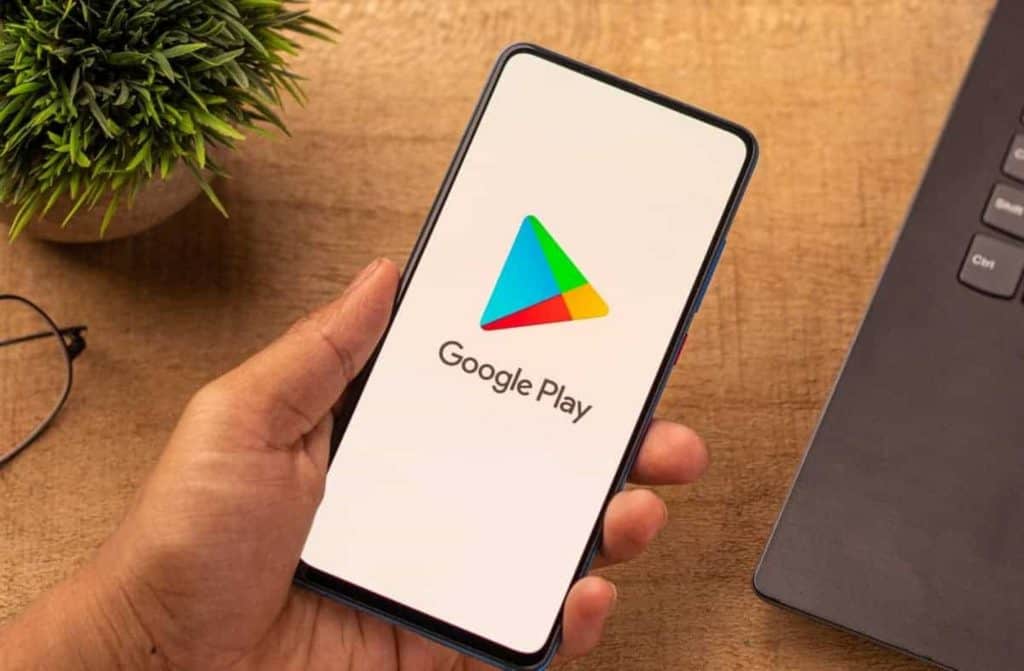 Logo do Google Play em um smartphone segurado por uma mão