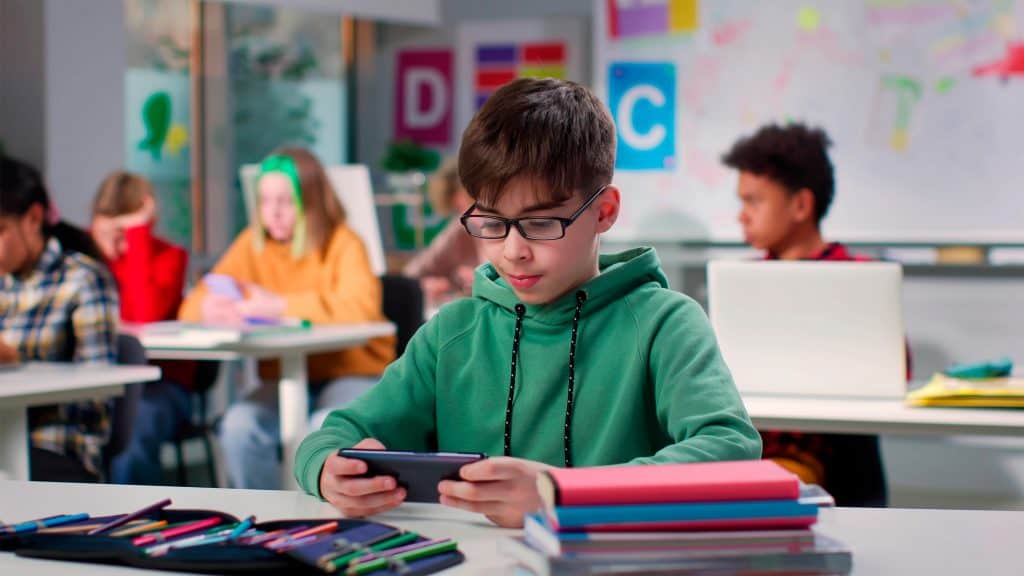 Garoto usando celular na escola